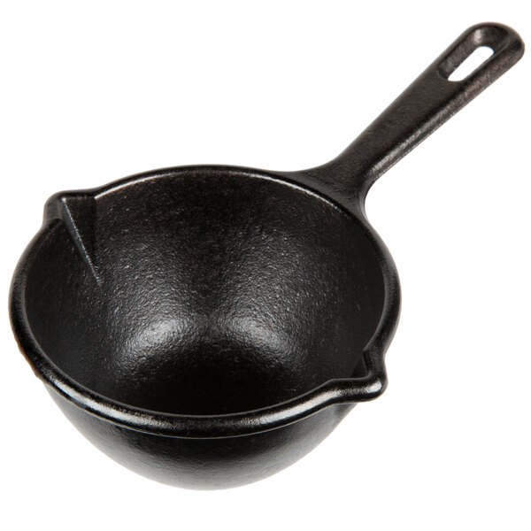 A black Lodge mini cast iron melting pot with a handle.