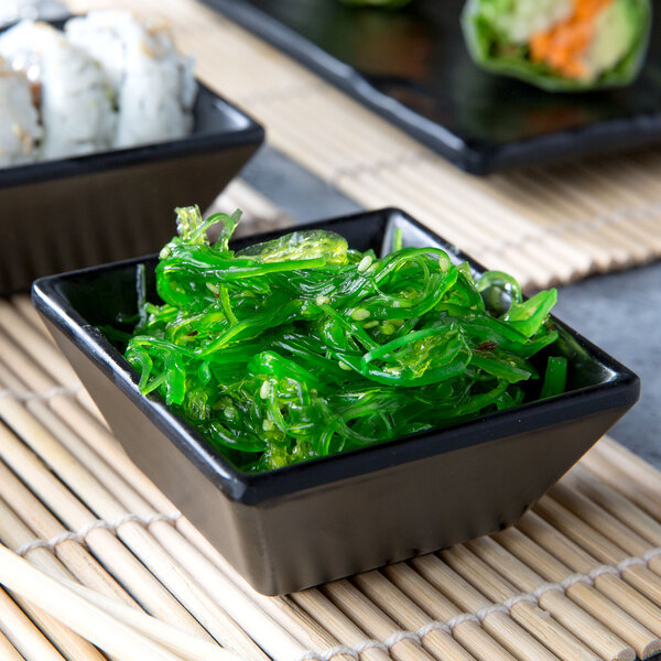 A black Elite Global Solutions square ramekin filled with green seaweed.