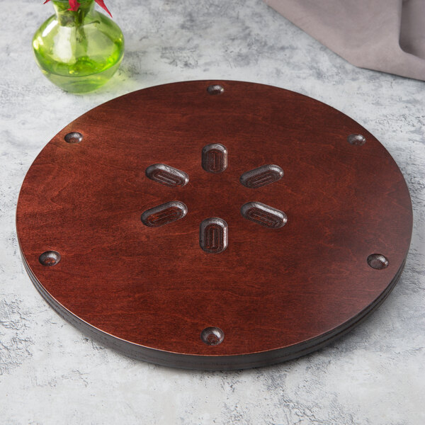 A circular wooden surface with a flower design.