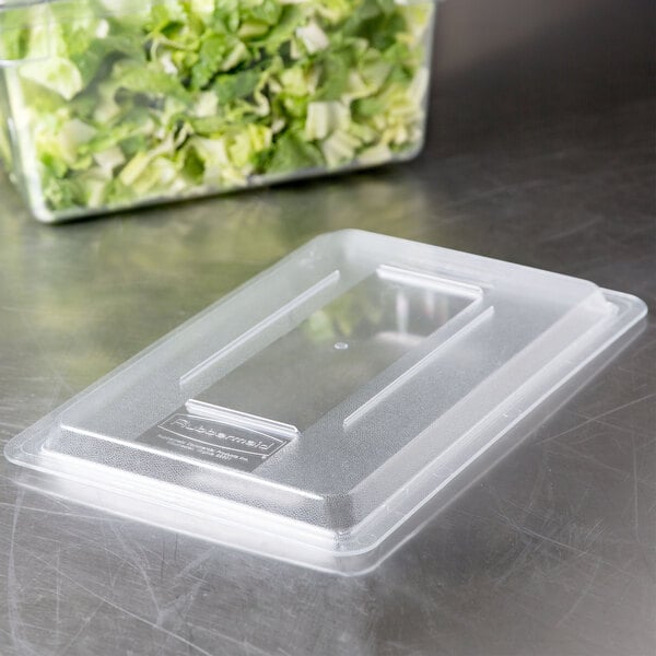 A clear Rubbermaid food storage container with lettuce inside and a clear lid.