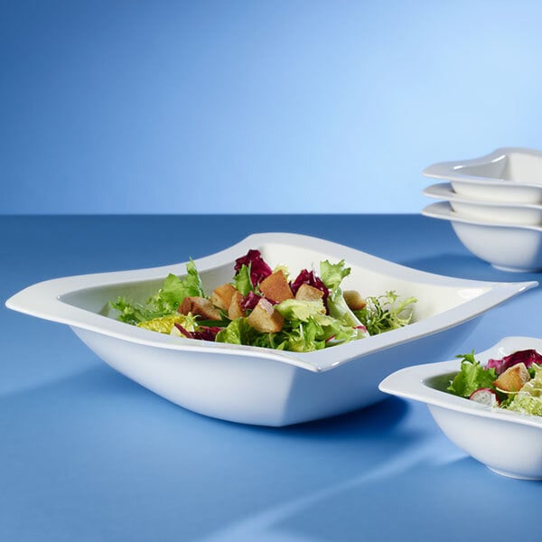 A close up of a white Villeroy & Boch NewWave square salad bowl with salad in it.