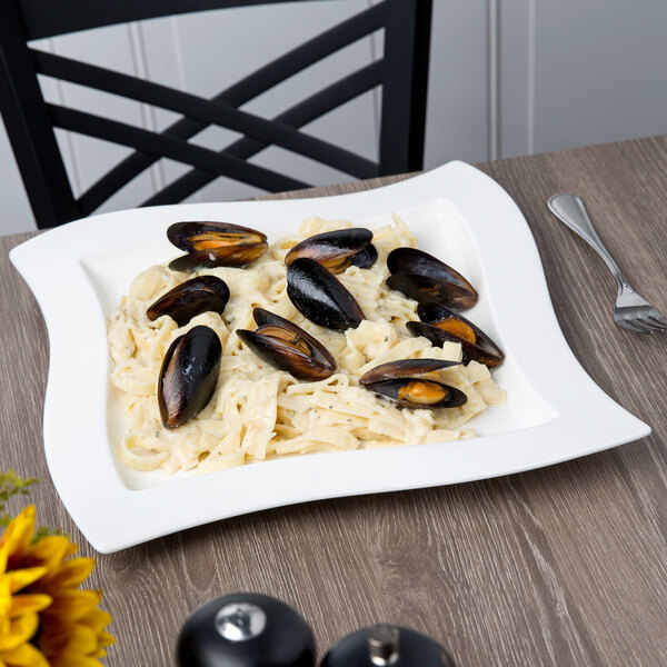 A Villeroy & Boch square white porcelain plate with pasta and mussels on it.