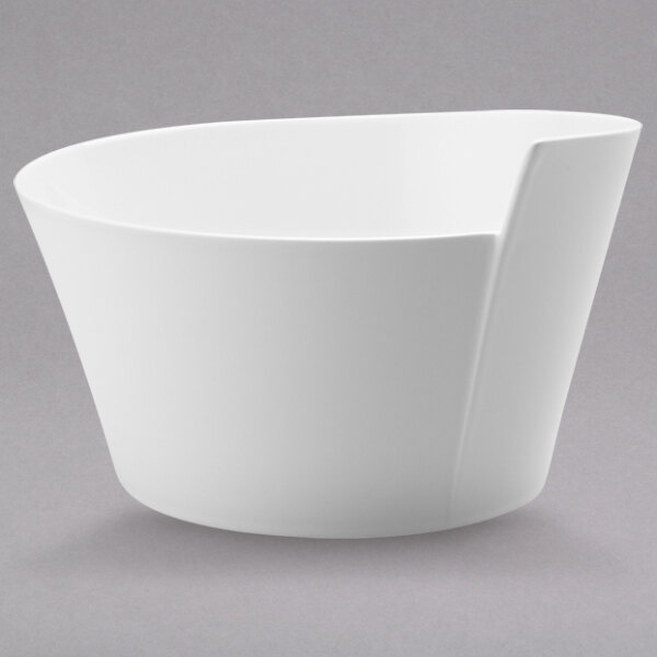 A close-up of a Villeroy & Boch NewWave white salad bowl with a curved edge.