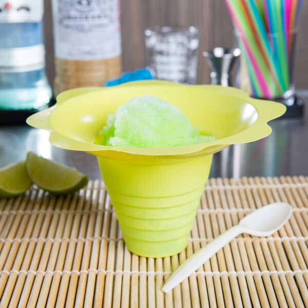 A yellow flower-shaped Sno-Cone cup with green ice.