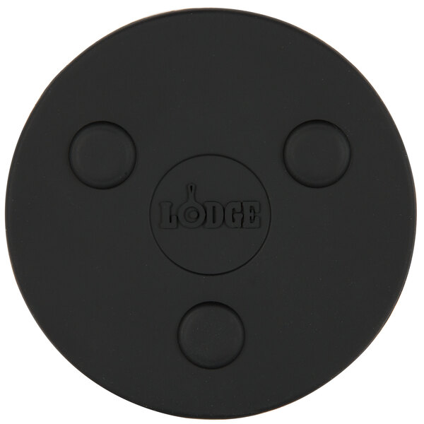 A black round Lodge magnetic trivet on a black surface.