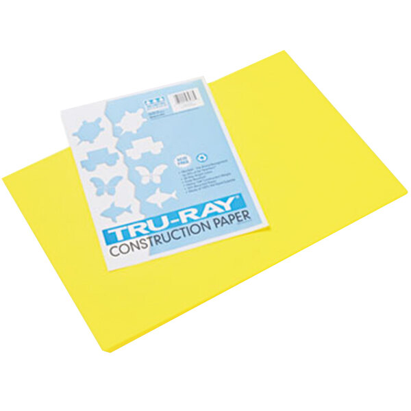 A yellow Pacon construction paper with a blue and white sign on it.