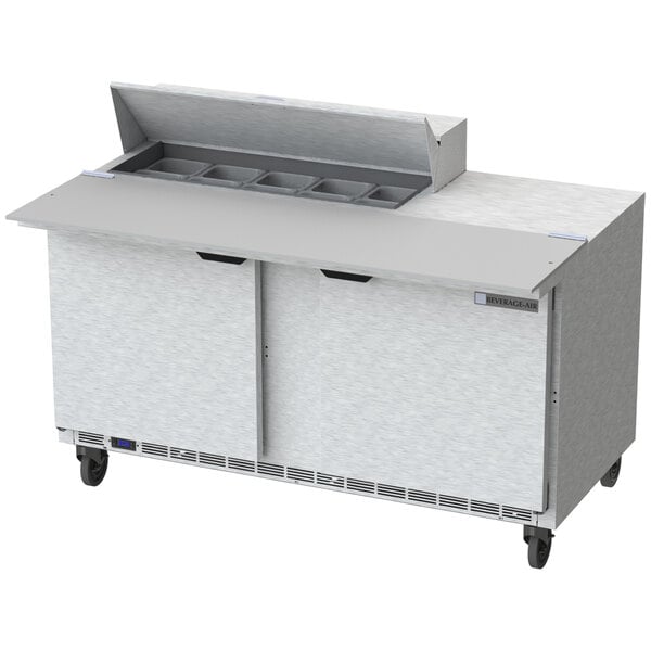 A Beverage-Air stainless steel sandwich prep table with a cutting board on top.