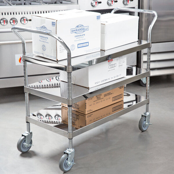 A Regency stainless steel utility cart with boxes on it.