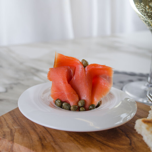A Bon Chef white porcelain sampler plate with a piece of salmon topped with capers.