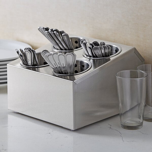 A metal container with a group of silverware inside.