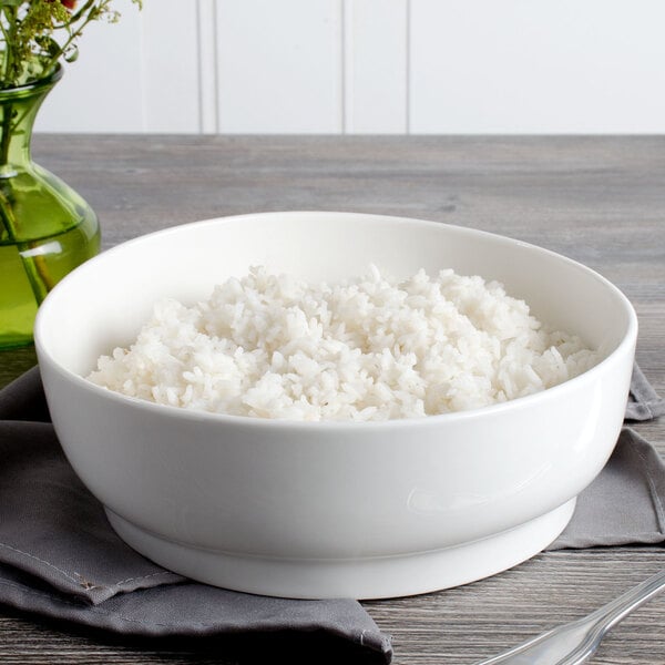 A white Bon Chef porcelain bowl filled with rice on a table.