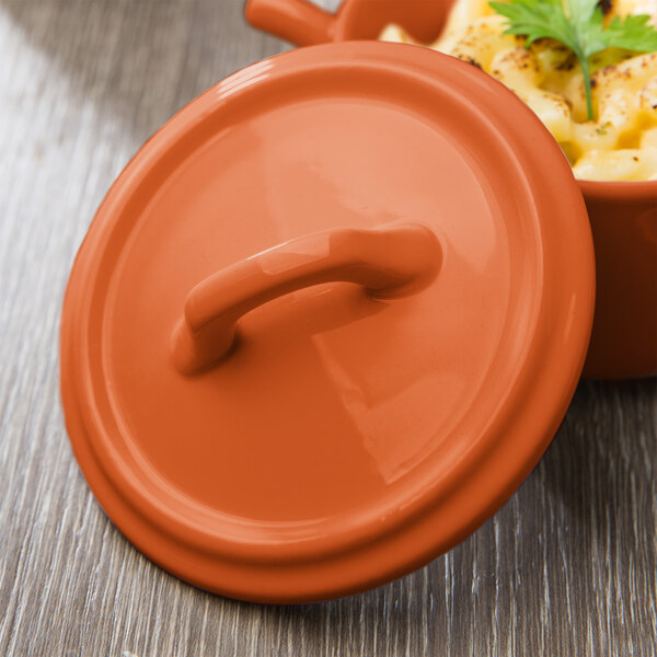 The lid for an orange Bon Chef porcelain casserole dish.