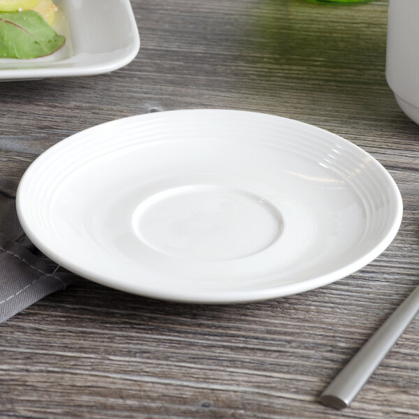 A white Bon Chef porcelain saucer on a table.
