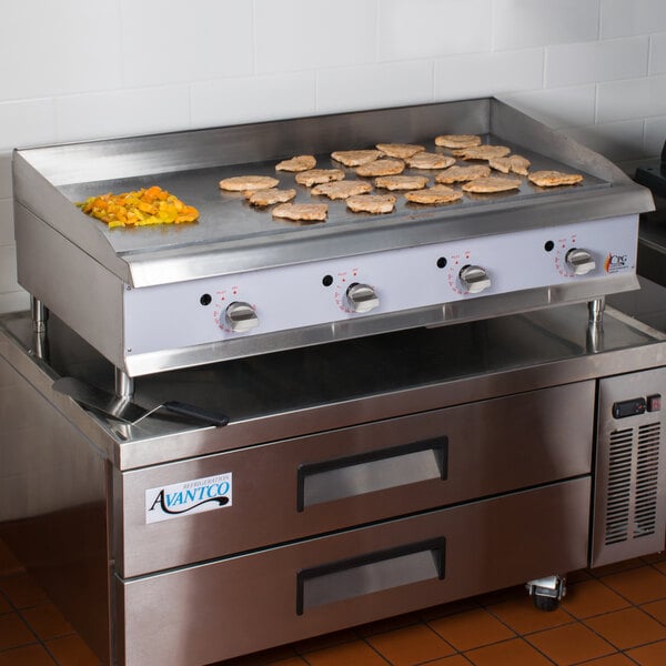A Cooking Performance Group gas countertop griddle with food cooking on it.