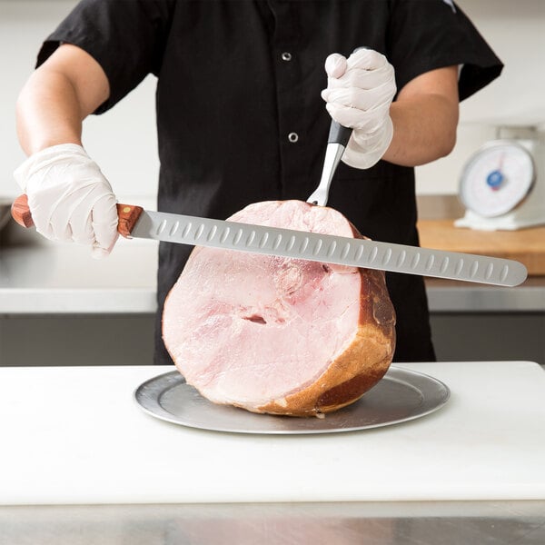 A person using a Mercer Culinary Praxis slicer knife to cut ham.