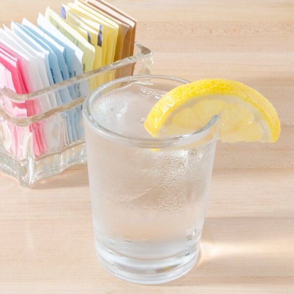 A Libbey side water glass with a slice of lemon and a lemon wedge in the glass.