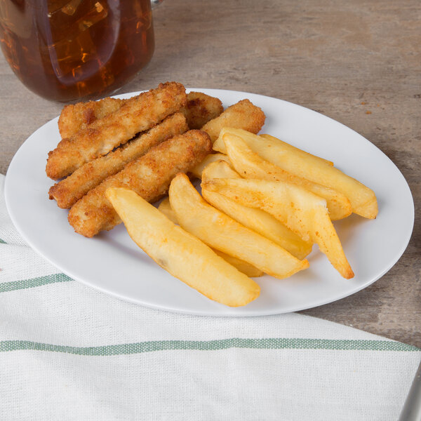 A white oval melamine platter with fried food on a table.