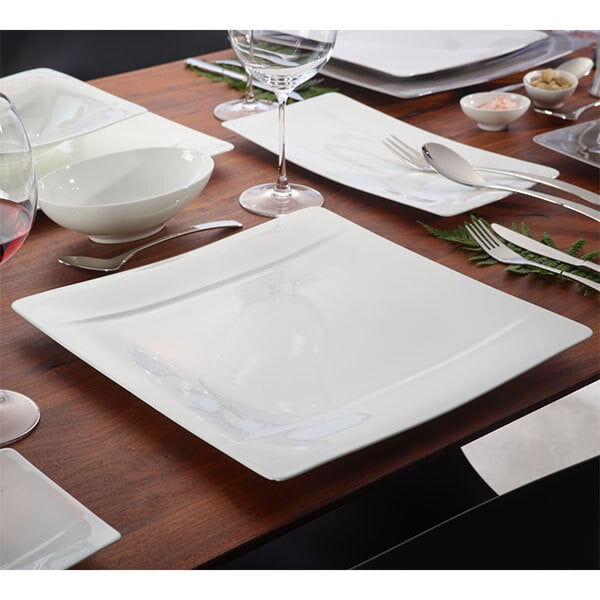 A white table set with Villeroy & Boch Modern Grace bone porcelain plates and utensils.