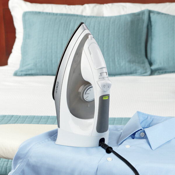 A white Conair full-featured hospitality iron steaming a shirt.