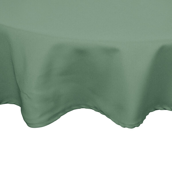A close-up of a round seafoam green Intedge tablecloth on a table.