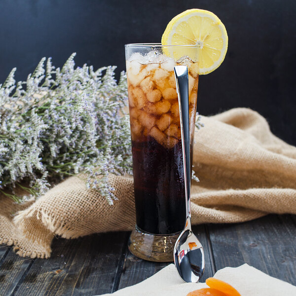 A glass of iced tea with a lemon slice and a Walco stainless steel iced tea spoon.