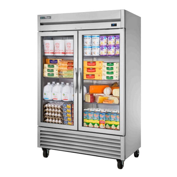 A True glass door reach-in refrigerator with dairy products inside.