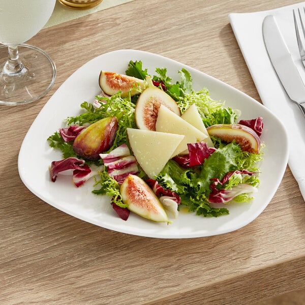 A plate of salad with figs, cheese, and lettuce on an Acopa Nova cream white porcelain plate.