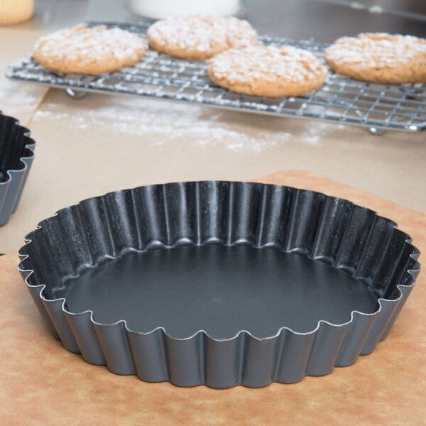 A black metal Matfer Bourgeat fluted tart pan on a counter.