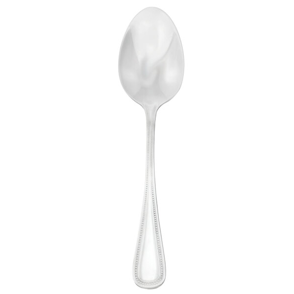 A Walco stainless steel serving spoon with a white handle.