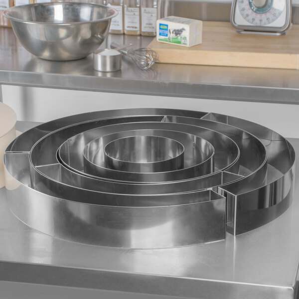 A Matfer Bourgeat stainless steel wedding cake ring set on a counter.