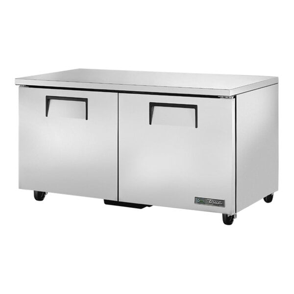 A stainless steel True undercounter freezer with drawers on wheels.