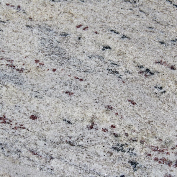 A close up of an Art Marble Furniture Kashmir White Granite Tabletop with red and white spots.