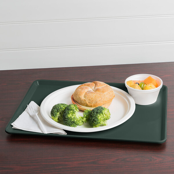 A Cambro slate blue dietary tray with a plate of food, a sandwich, and a drink.