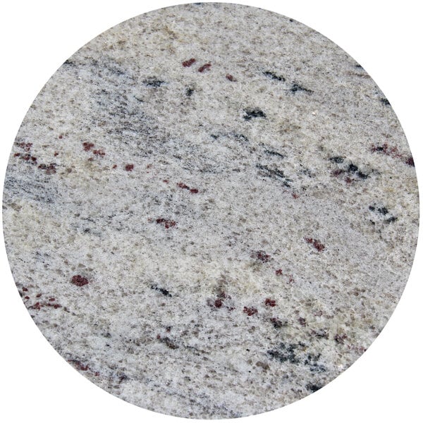 A close up of a round Kashmir white granite tabletop with red and black spots.