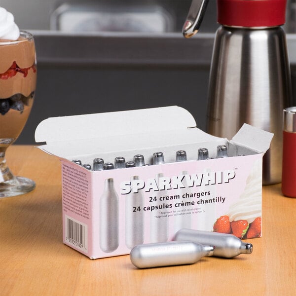 A box of Sparkwhip N2O cream chargers on a table.