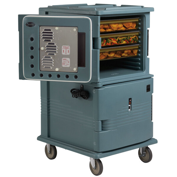 A grey Cambro Ultra Camcart holding trays of food in a large oven.