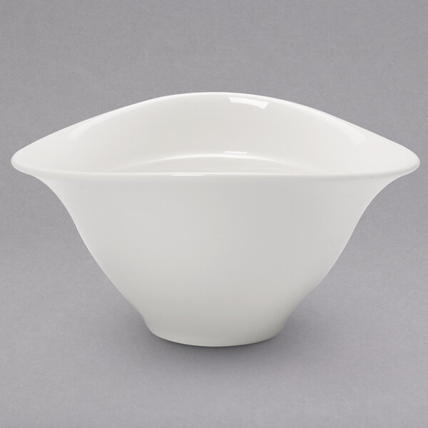 A white Villeroy & Boch porcelain bouillon cup with a curved edge on a gray surface.