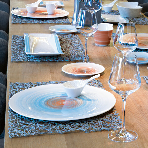 A table with Villeroy & Boch aquamarine porcelain flat coupe plates and glasses.