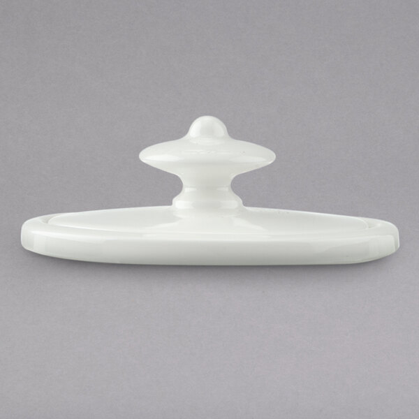 A close-up of a white porcelain Villeroy & Boch coffeepot lid with a white plastic knob.