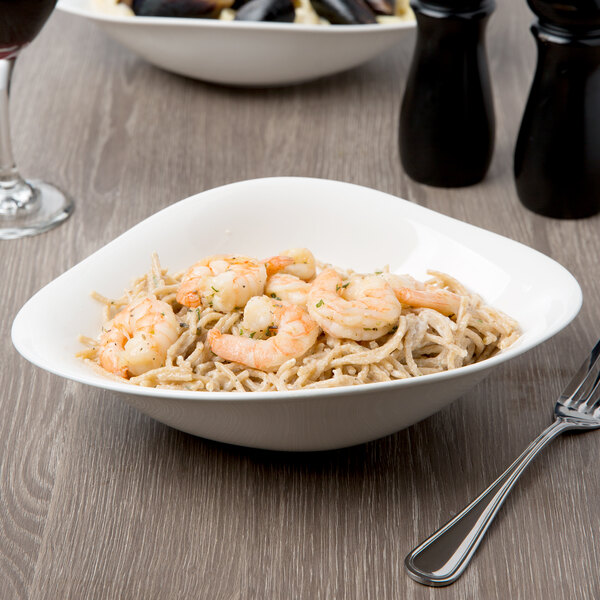 A Villeroy & Boch white porcelain deep bowl filled with shrimp and noodles on a table.