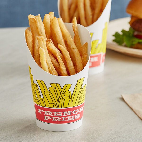 French fries in a Choice paper scoop cup with a fry design on a table with hamburgers.