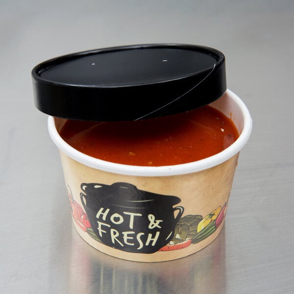 A black cylinder with a black lid filled with hot soup.