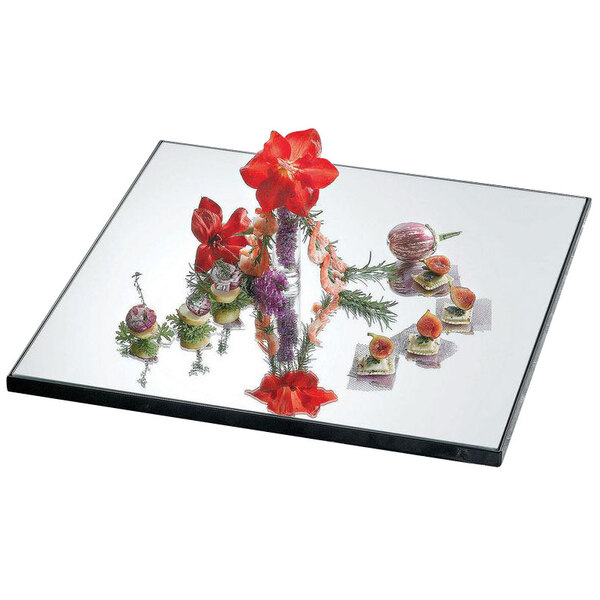A Bon Chef sandstone glass mirror tray with a flower arrangement on it.