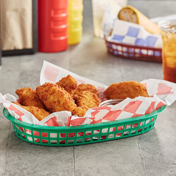 A green oval plastic fast food basket filled with fried chicken and fries.