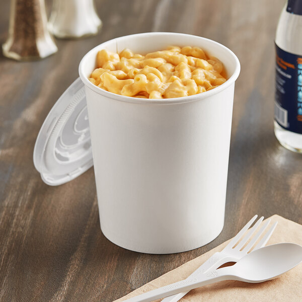 A white Choice paper food cup filled with macaroni and cheese on a table.