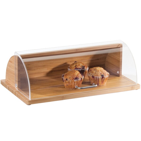 A Cal-Mil Bamboo roll top tray on a wooden counter with muffins inside.