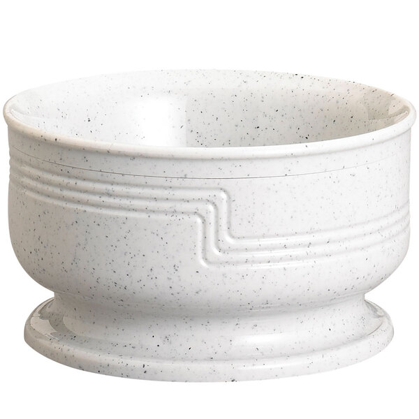 A white bowl with black specks on the bottom.
