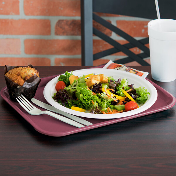 A Vollrath burgundy fast food tray with a salad and muffin on it.