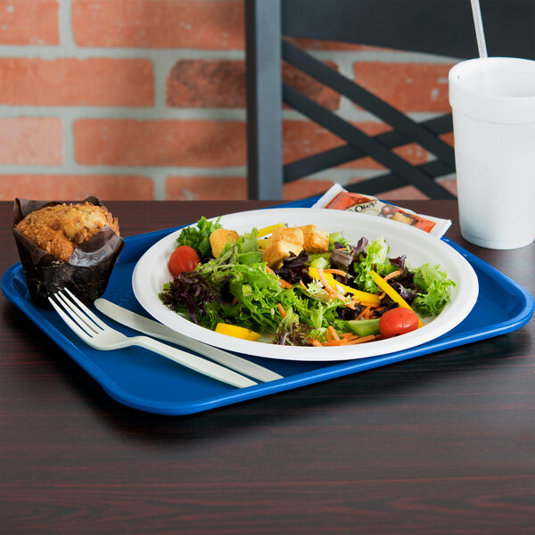 A Vollrath fast food tray with a plate of salad, muffin, and white utensils.