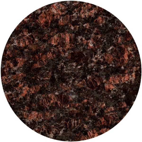 A close up of a Art Marble Furniture round tan brown granite tabletop with black and red speckled spots.